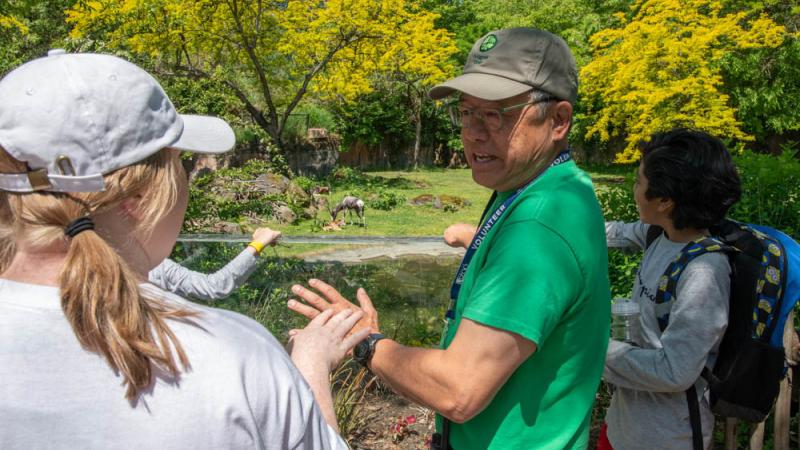 volunteer speaking with zoo visitors near bontebok
